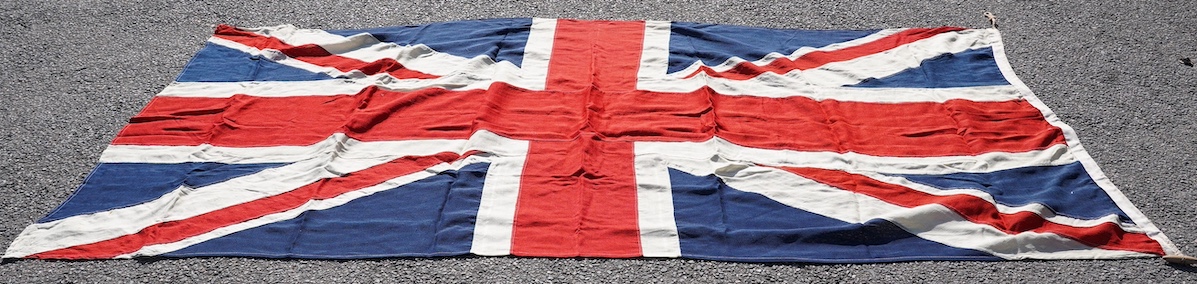 A vintage Union flag, approximately 240 x 120cm, a smaller “Sale” flag and other assorted flags and bunting. Condition - fair